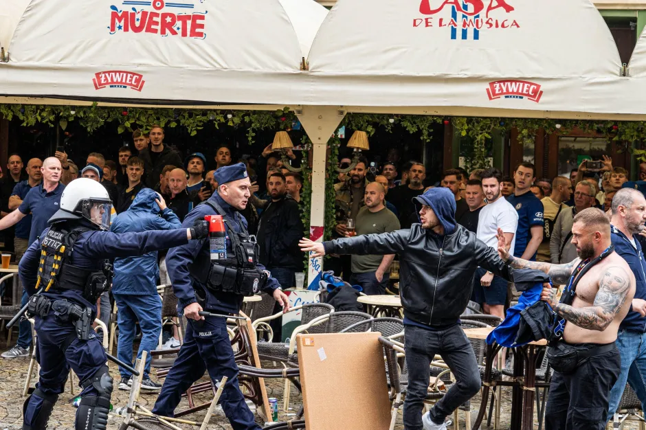 Police officers intervening in a confrontation between soccer fans.
