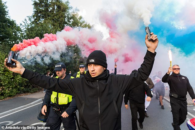 Demonstrators set off smoke flares as they march towards The Bell Hotel in a protest against housing of asylum seekers in Epping, United Kingdom on August 31, 2025