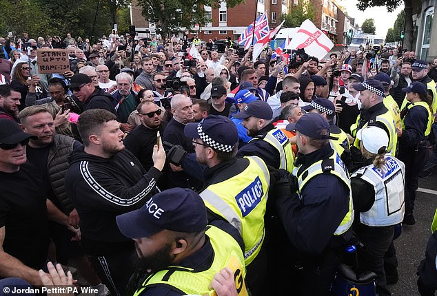 Demonstrators protest to stop a police van leaving after a protester was detained by police after hanging a Union flag from the civic offices, as they march in Epping, Essex