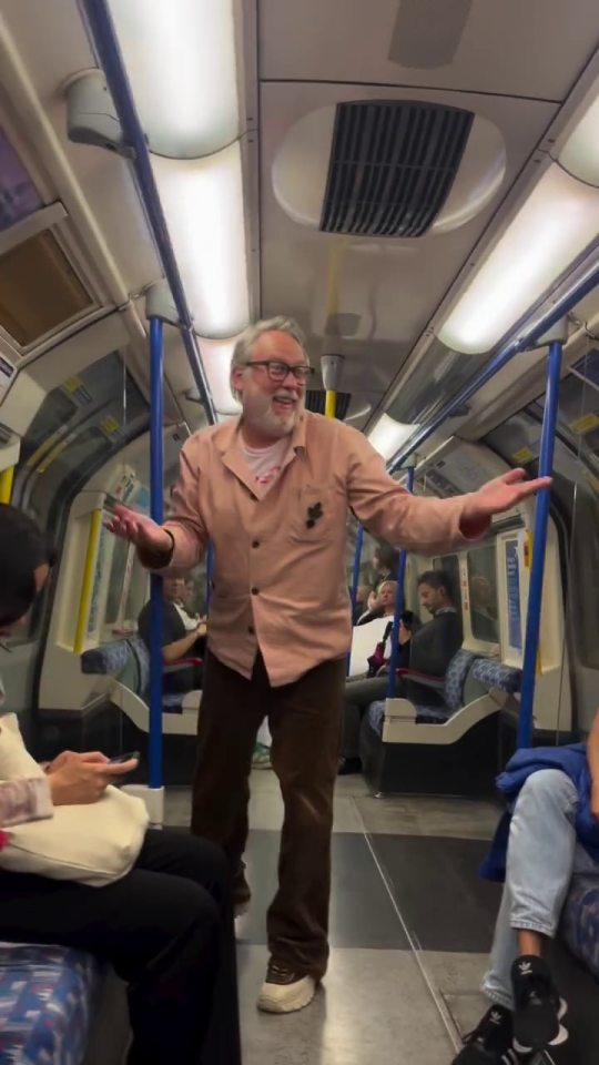 A 66-year-old comedy legend swinging from a handrail on a London Underground train.