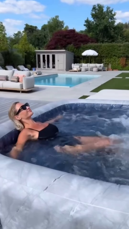 Woman relaxing in a hot tub next to a swimming pool.