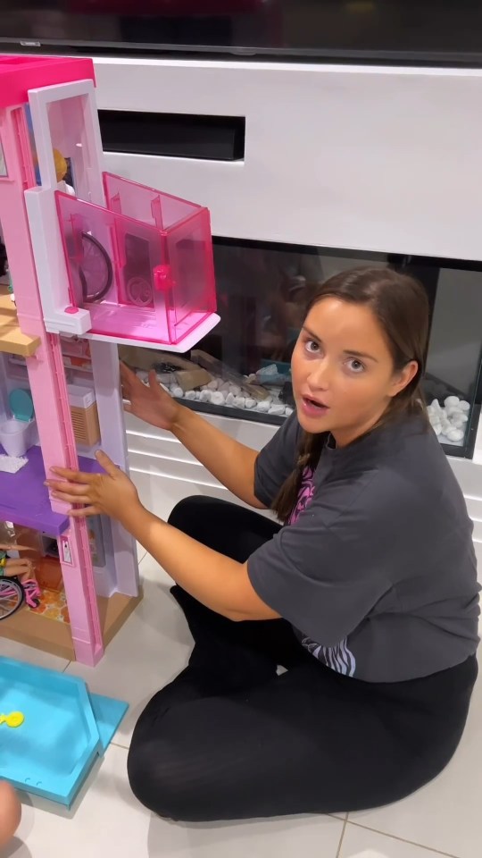Woman assembling a Barbie Dreamhouse.