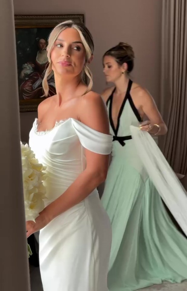 Bride in white wedding dress with bridesmaid in mint green dress.