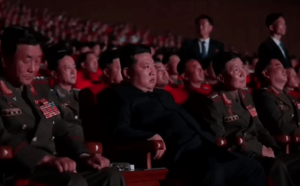 Kim Jong-un and military officials seated in an auditorium.