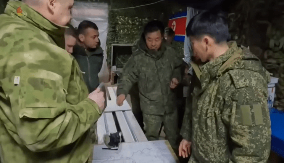 North Korean soldiers reviewing a map with Russian soldiers.