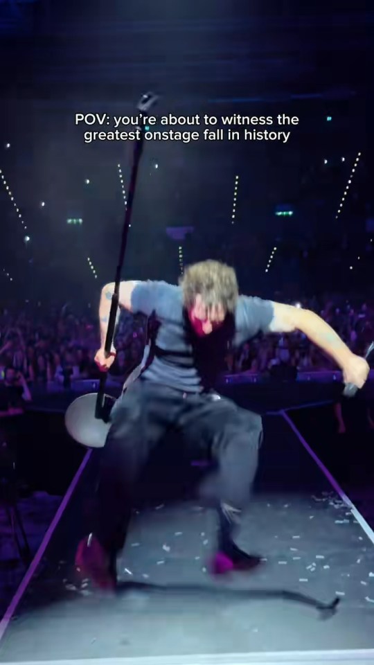 Tom Grennan falling on stage during a concert.