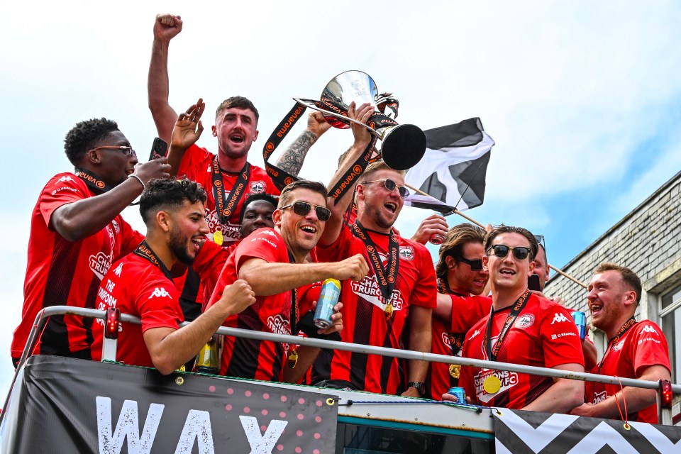 Truro City FC players celebrating on an open-top bus after winning the National League South.