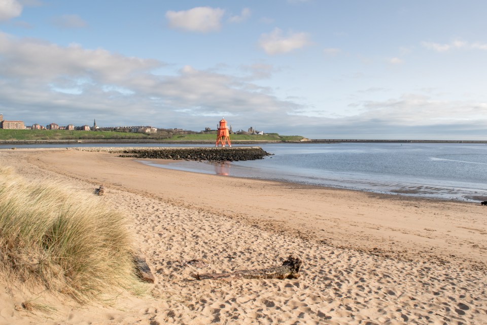 South Shields beach with an orange lighthouse.