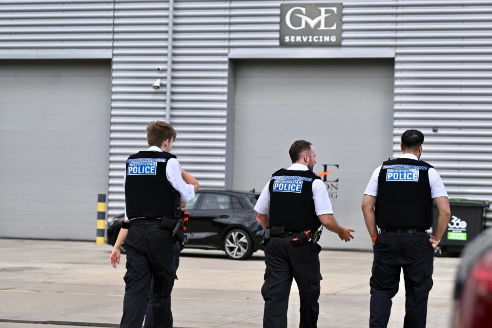 Three Metropolitan Police officers outside a car dealership.