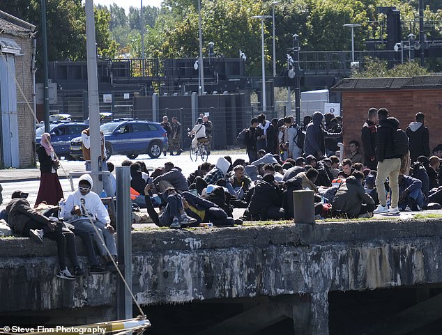 The groups sat or lay down on the port at Gravelines near Calais, possibly waiting for a small boat