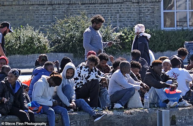 As well as men, some women and small children sat around, possible waiting to cross