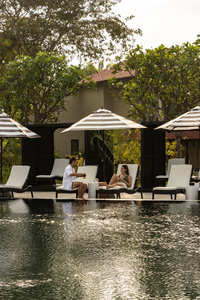 Couple relaxing by a resort pool.