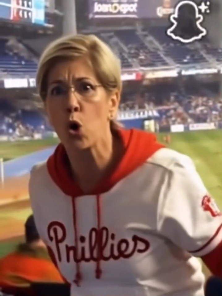 Woman in Phillies sweatshirt yelling at baseball game.