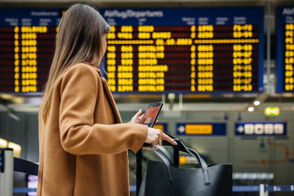 Woman at airport checking her phone.
