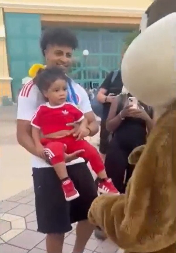 Raphinha's son being ignored by a Disneyland Paris mascot.