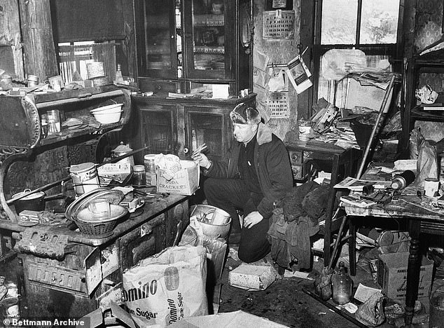 Gein pictured kneeling on the floor of his filthy kitchen in this dilapidated farm house where human skulls and body parts were found