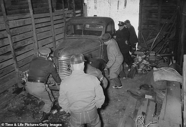 Investigators move a car as they search for evidence in his garage