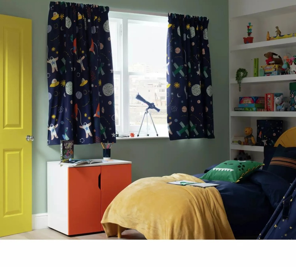 Child's bedroom with space-themed curtains.