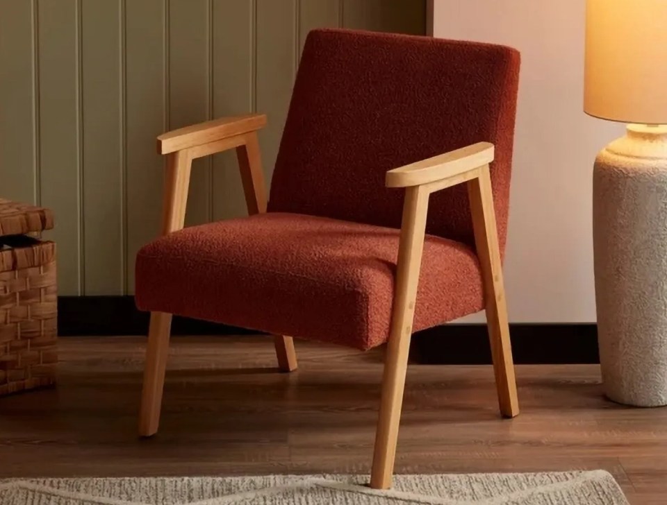 Red mid-century armchair on a rug.