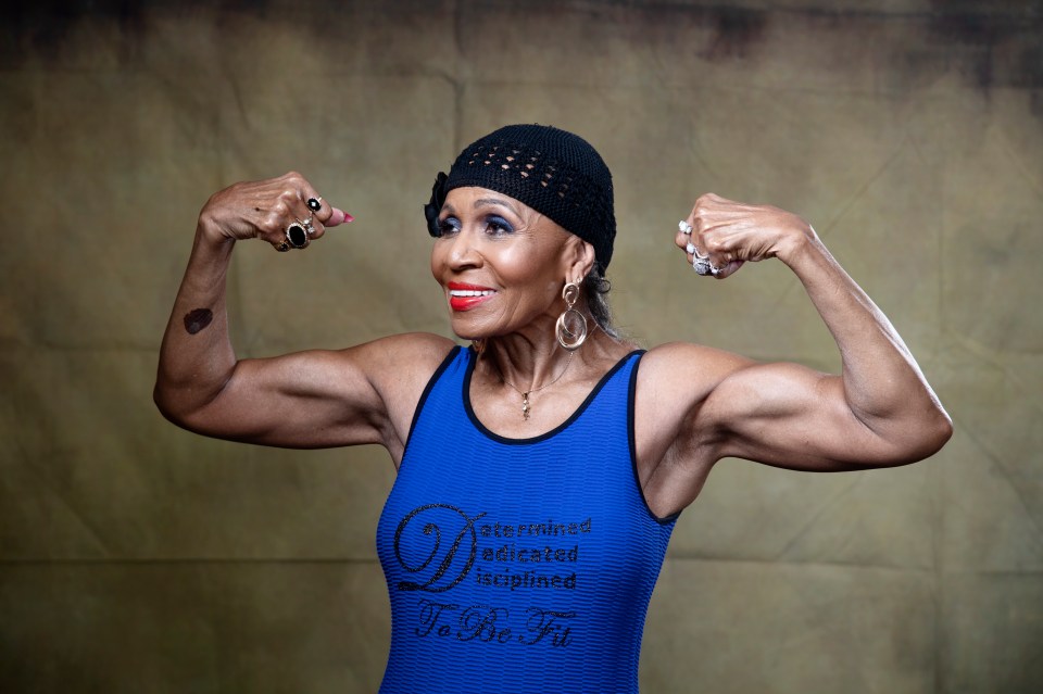 Portrait of Ernestine Shepherd, a bodybuilder, flexing her biceps.