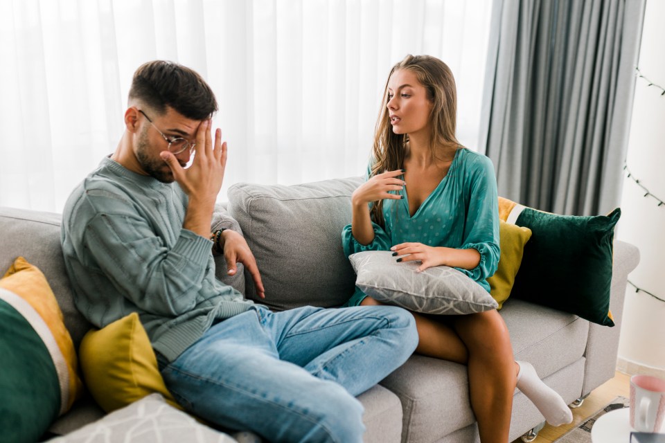 Young couple arguing on a couch.