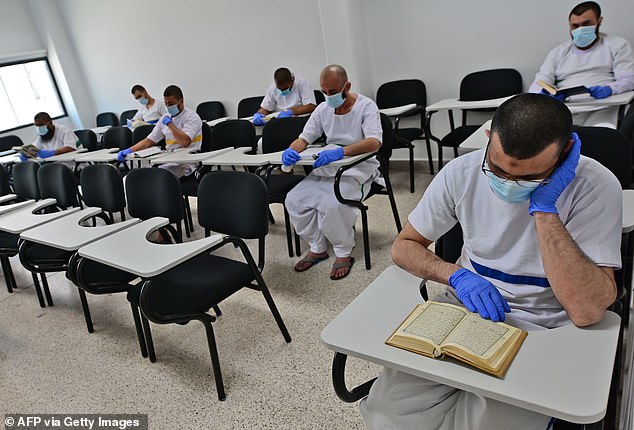 Inmates wearing protective gear read in seats respecting distancing measures amid the COVID-19 pandemic, at the library of Dubai's Al-Awir central prison in the United Arab Emirates, on May 21, 2020