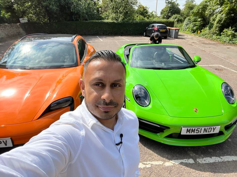 Self-made millionaire posing with two luxury cars.