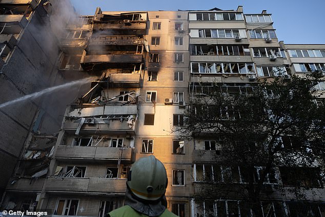 Firefighters are seen hosing down a residential block in Kyiv following Russia's drone attack -- September 7, 2025