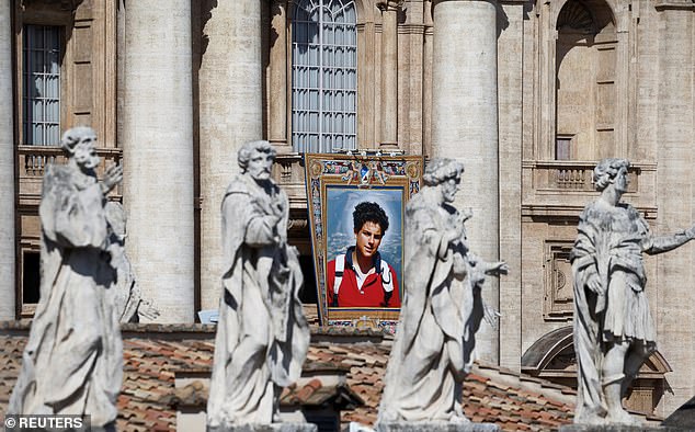 A tapestry depicting an image of Carlo Acutis hangs on the facade of St. Peter's Basilica, on the day Pope Leo XIV leads a Holy Mass for the canonisation of Carlo Acutis