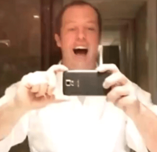 Man taking selfie in bathroom mirror.