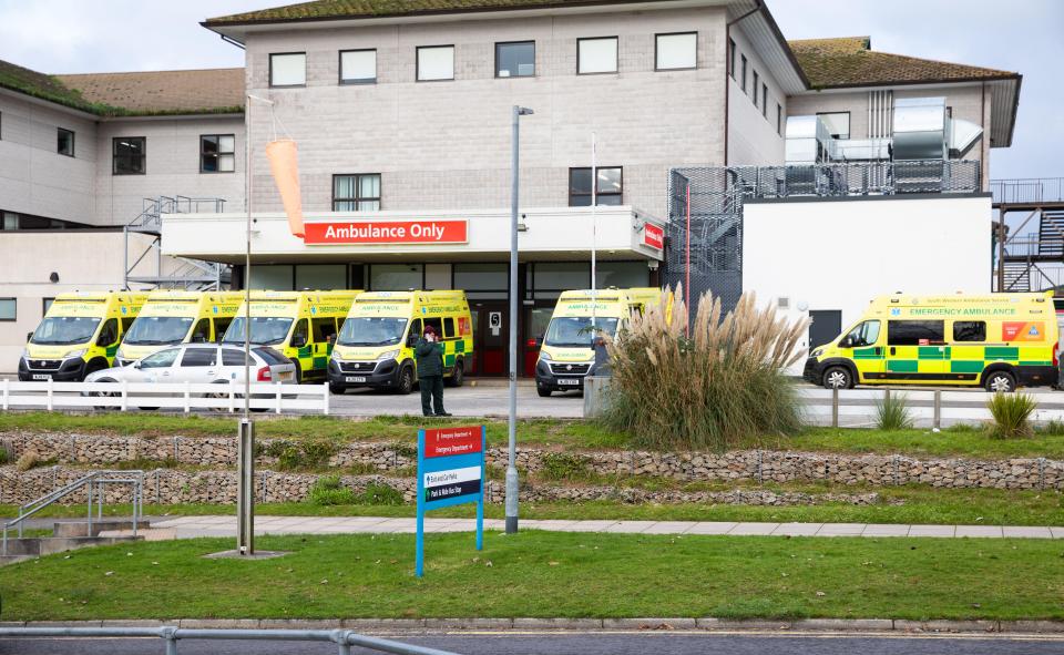 Ambulances waiting outside a hospital's emergency department.