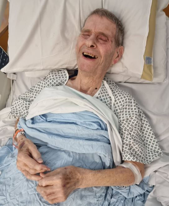 Elderly man lying in a hospital bed.