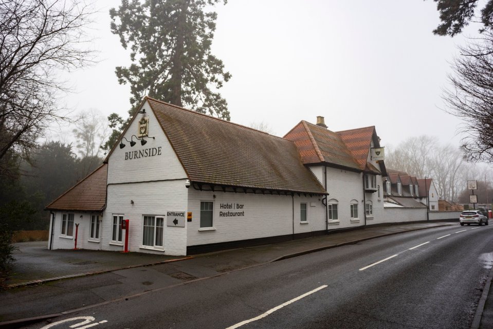 The Burnside Hotel, a white building with brown roof, located on a road.