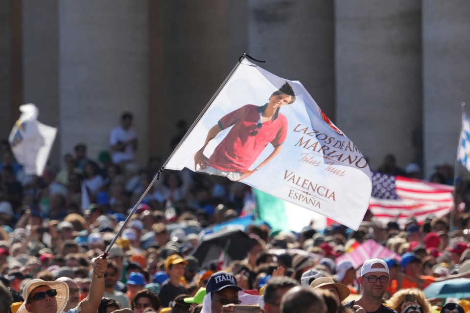 Flag depicting Carlo Acutis at a canonization Mass.