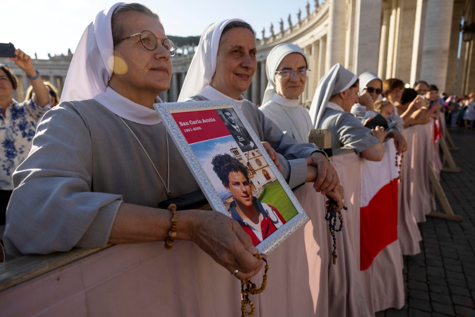 Nuns holding a picture of Carlo Acutis at his canonization.