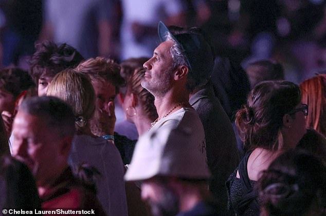 Meanwhile director Taika, 50, wore a cream graphic t-shirt and baggy blue jeans, which he paired with a green baseball cap,a gold chain and white trainers