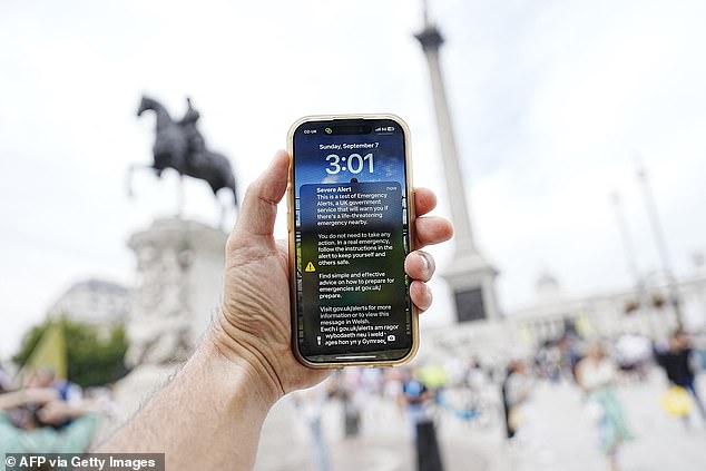 An Emergency Alert is pictured on the screen of a smart phone in central London today