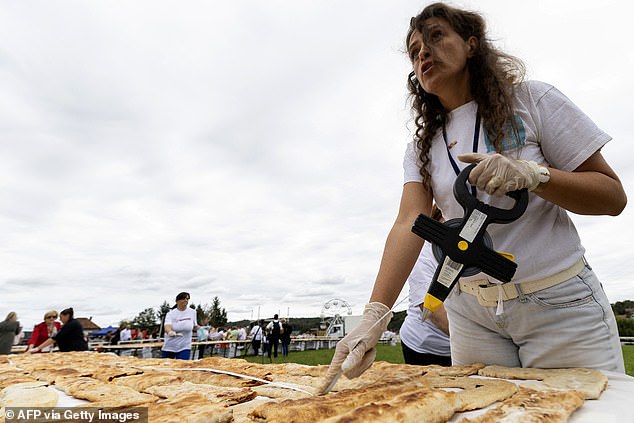 A woman measures the length of strudels during the regional festival in Croatia
