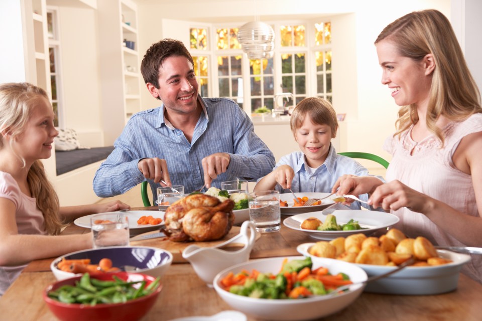 Family enjoying roast chicken dinner together.