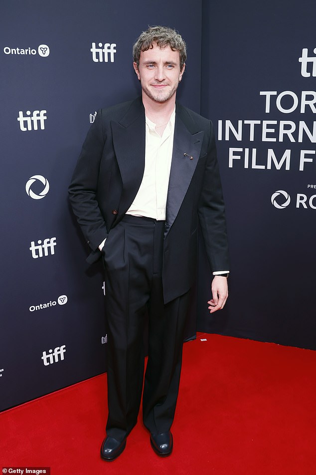 Paul layered the look over a crisp white shirt but forwent a tie and added a safety spin to his oversized satin lapel