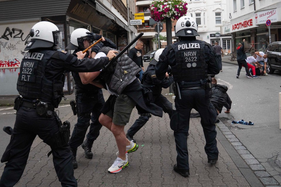Police officers subduing fighting soccer fans.