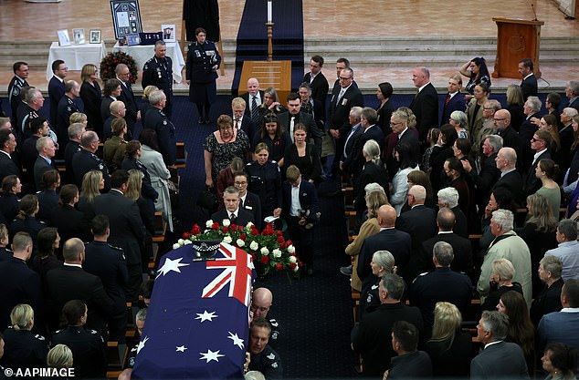 A general view as Sergeant Lisa Thompson , partner of Neal Thompson, joins family and friends departing the funeral service for Detective Leading Senior Constable Neal Thompson at the Victoria Police Academy Chapel in Melbourne, Monday, September 8, 2025. (AAP Image/Con Chronis) NO ARCHIVING, POOL