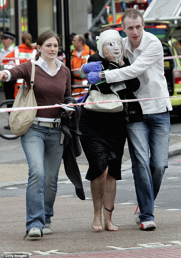 Paul Dadge (R), 28, and an unidentified person help Davinia Turrell (C), 24, to safety at Edgware Road underground station after several bomb blasts