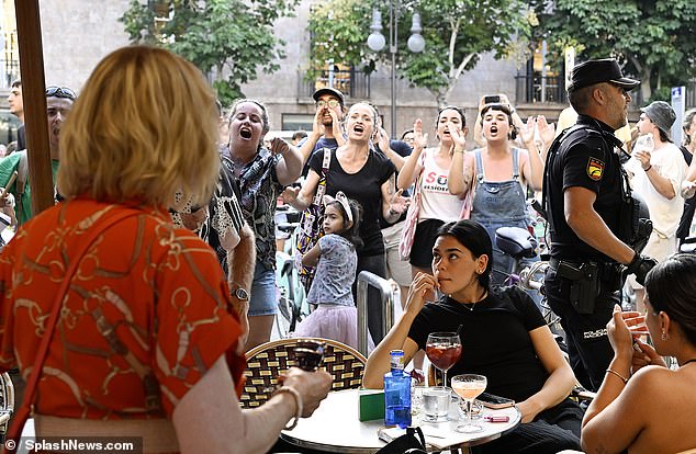 The decline on tourism has been blamed on hostile anti-tourism protests ravaging Spain. Pictured: Demonstrators heckle holidaymakers enjoying their evening meals in Mallorca