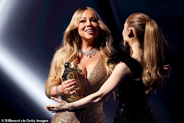 After receiving her first-ever VMAs on Sunday night, Mariah Carey shaded MTV for waiting so long to recognize her and her work; seen receiving an award from Ariana Grande