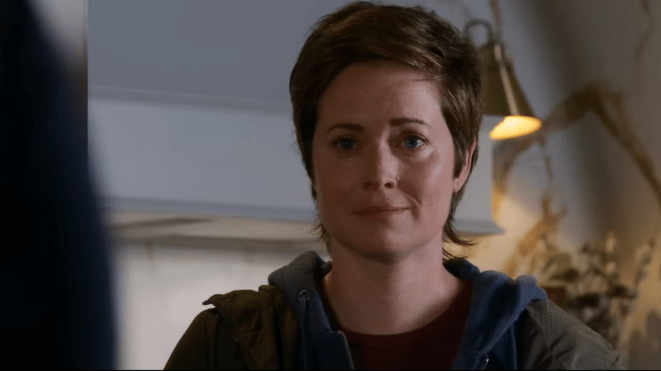 Screenshot of a woman with short brown hair looking sad.
