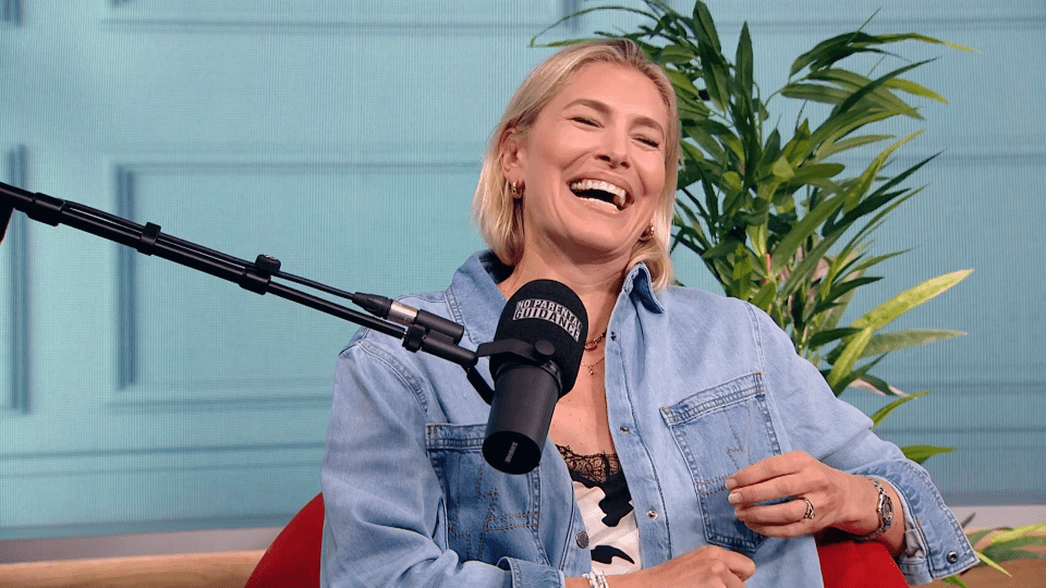 Woman laughing at a podcast recording.