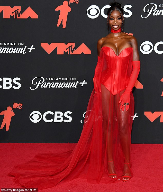 Olandria Carthen was glamorous in a red ensemble, complete with matching gloves and a sheer train