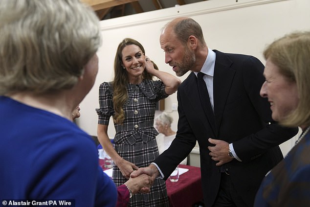 The Prince and Princess of Wales are welcomed by members during a visit to the National Federation of Women's Institute