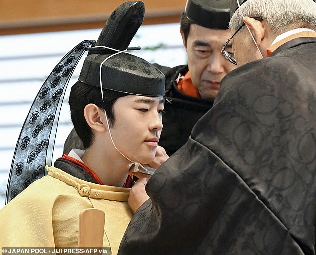 He was assisted when it came to putting on the elaborate attire for the ceremony